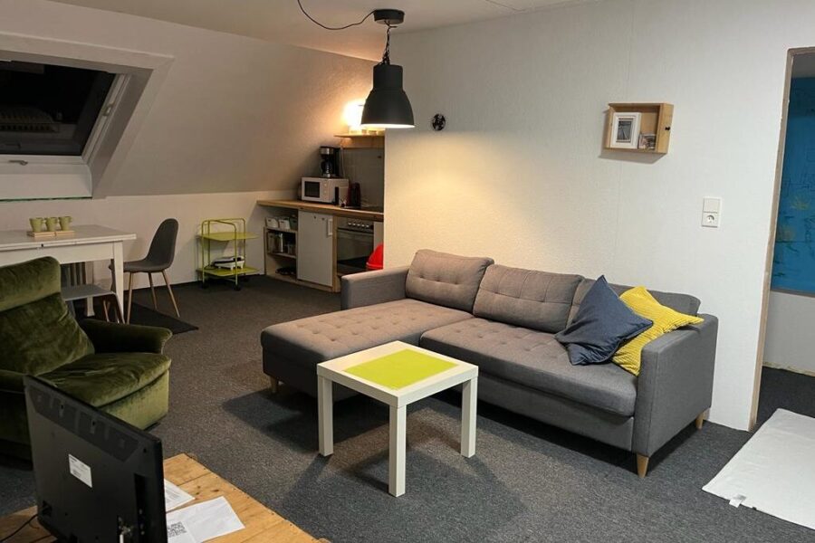 Wohnraum mit Sofa und Fernseher im Sporthostel am Schluchsee